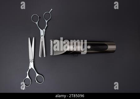 Hairdressing scissors and Machine for a hairstyle on black background. Hairdresser salon equipment concept, premium hairdressing shears. Accessories f Stock Photo