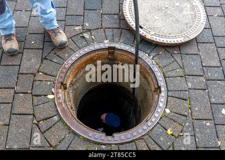 Blocked pipe. Sewer inspection with camera. Sewer cleaning company worker at work in a manhole Stock Photo
