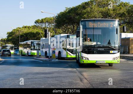 Valletta, Malta - 17 June 2023: In the Floriana district, green public service buses departing. Stock Photo