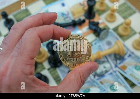 a bitcoin is in my hand between my fingers Stock Photo