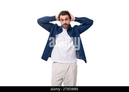 portrait of a young European brutal brunette man with a cool hairstyle dressed stylishly and fashionably in a denim shirt Stock Photo