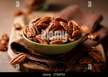Pecan nuts in a bowl on a brown background Stock Photo