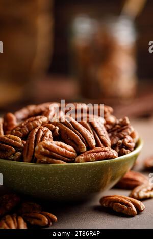 Pecan nuts in a bowl on a brown background Stock Photo