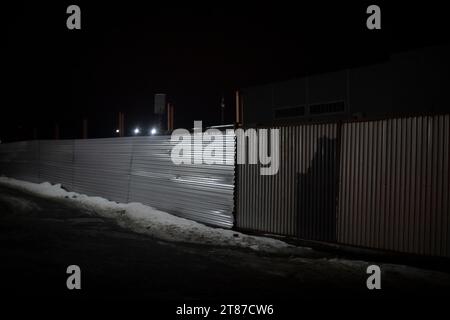 Steel fence at night. Private area in evening. Fence around industrial area. Details of territory. Stock Photo