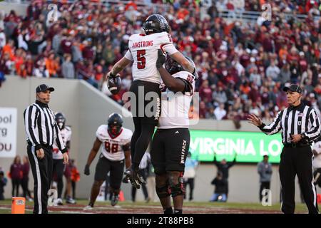 Blacksburg, Virginia, USA. 18th Nov, 2023. North Carolina State Wolfpack quarterback Brennan Armstrong (5) celebrates a touchdown with offensive lineman Timothy McKay (52) during the NCAA football game between the North Carolina State Wolfpack and the Virginia Tech Hokies at Lane Stadium in Blacksburg, Virginia. Greg Atkins/CSM/Alamy Live News Stock Photo