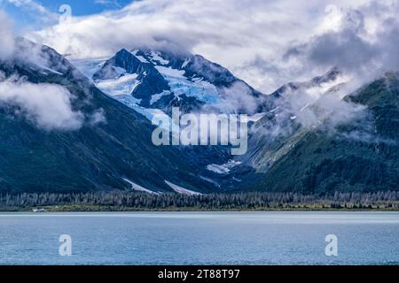 Moody clouds float over the Byron Glacier above Portage Lake in Chugach National Forest, Alaska. Stock Photo