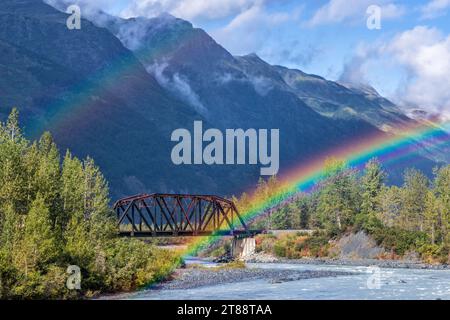 The end (or beginning) of a double rainbow on an Alaska Railroad bridge over the Placer River near Spencer Glacier in Chugach National Forest, Alaska. Stock Photo