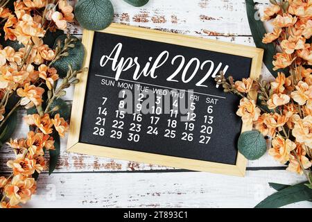 April 2024 monthly calendar with flower bouquet decoration  on wooden background Stock Photo