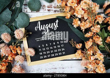 August 2024 monthly calendar with flower bouquet decoration  on wooden background Stock Photo