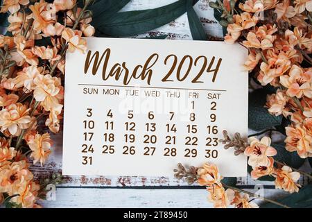 March 2024 monthly calendar with flower bouquet decoration  on wooden background Stock Photo