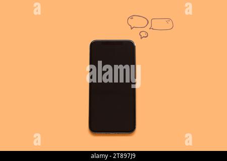 Mobile phone with blank screen and speech bubbles on orange background Stock Photo