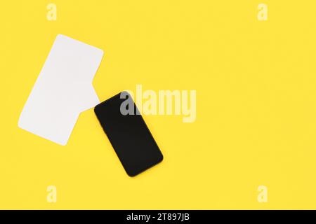 Mobile phone with empty screen and blank speech bubble on yellow background Stock Photo