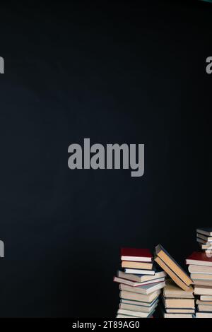 large number of books stacked on a black background in the library science knowledge Stock Photo