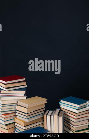 large number of books stacked on a black background in the library science knowledge Stock Photo