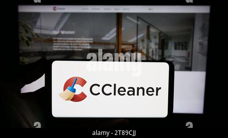 Person holding smartphone with logo of computer system clearning software CCleaner in front of website. Focus on phone display. Stock Photo