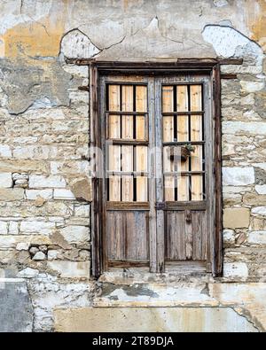 Old wooden door in a brick wall of an old house. Limassol. Cyprus Stock Photo