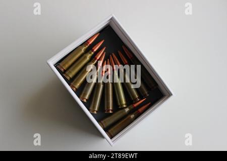 Top view of white box with unitary cartridges lined up bullets to bullets in a white box Stock Photo