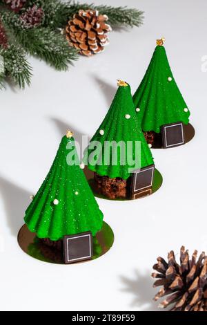 Green Christmas trees shaped cakes on table with cones Stock Photo