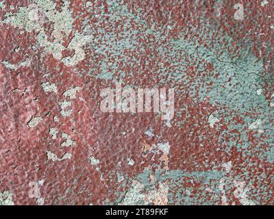 Background from an old coat of red paint peeling off a wall Stock Photo