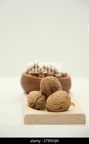 Walnut kernel halves, in a wooden bowl. Shelled, dried seeds used as snack or for baking. Close-up, Stock Photo