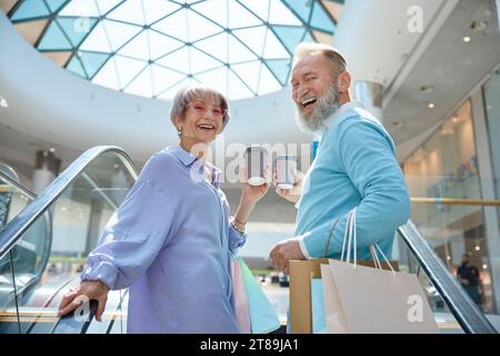 Adult senior couple with purchases having fun time at shopping mall Stock Photo
