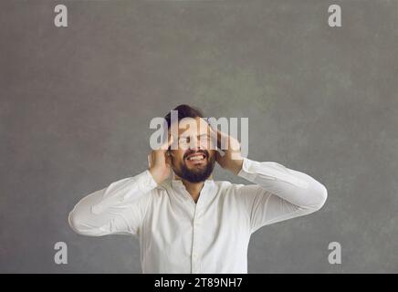 Exhausted employee suffers from a severe headache caused by stress and emotional burnout. Stock Photo