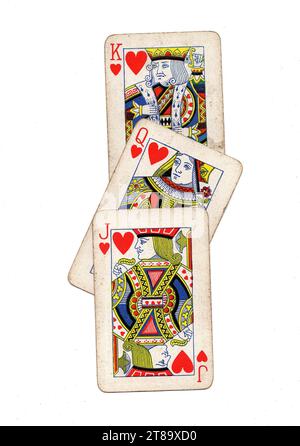 Vintage playing cards showing a run of jack, queen and king of hearts on a white background. Stock Photo