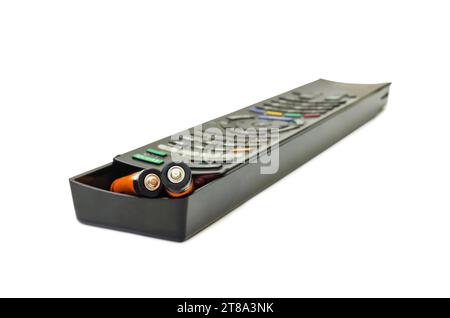 AA batteries and TV remote control. Replacing the batteries in the remote control. Stock Photo