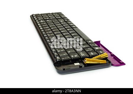 Black wireless keyboard with purple cover and two batteries. Background white Stock Photo