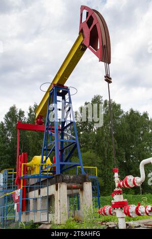 oil pump stands on an oil field in a summer forest Stock Photo