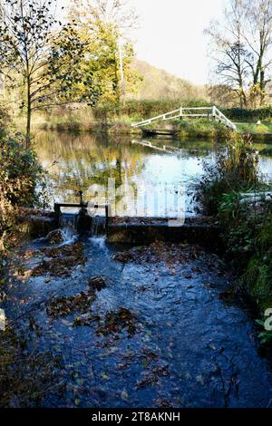 Cromford, Derbyshire, UK, November 17, 2023. Wooden footbridge and weir  on The Cromford Canal. Stock Photo