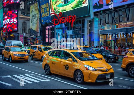 Yellow Taxicabs on Times Square, New York City, USA. Yellow Taxi Cabs Lined Up Waiting At Stop Sign In Early Evening Light, Times Square, New York. Stock Photo