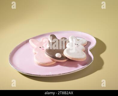 Easter's Finest Dessert Treats: Three Adorable Bunny Rabbit Cookies on a Pastel Pink Plate Stock Photo