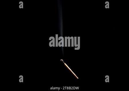 Lit and falling match on a black background. Stock Photo