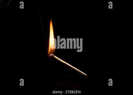 Lit and falling match on a black background. Stock Photo
