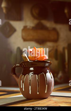 Mexican Champurrado Hot Chocolate in Traditional Rustic Clay Jarritos Mug with Cinnamon Stick Stock Photo