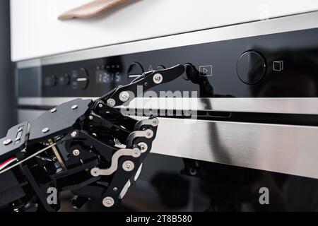 Real robot's hand and microwave oven. Concept of robotic process automation Stock Photo