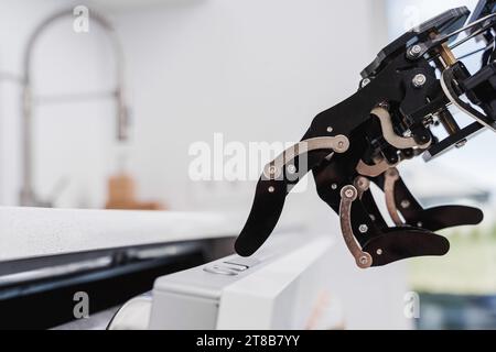 Real robot hand pushing button on dishwasher. Concept of Artificial intelligence development and robotic process automation Stock Photo