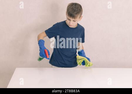 little boy cleans the glass table in the house Stock Photo