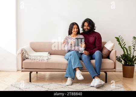 Cheerful indian man and woman using digital tablet Stock Photo