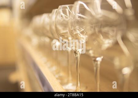 empty glass goblets for wine and other drinks on a wooden shelf on a blurred background. High quality photo Stock Photo