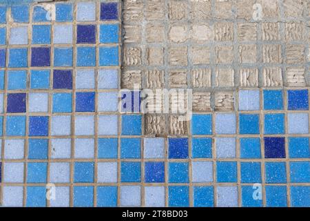part of a wall in blue mosaic close-up on a gray plastered wall Stock Photo