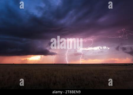 An ominous, stormy sky with lightning bolts at sunset near House, New Mexico Stock Photo