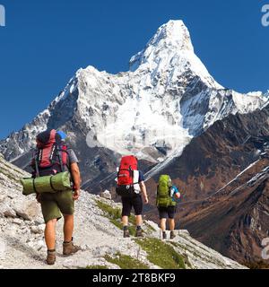 Mount Ama Dablam and three hikers, way to Mt Everest base camp, Khumbu valley, Sagarmatha national park, Everest area, Nepal Himalayas mountains Stock Photo