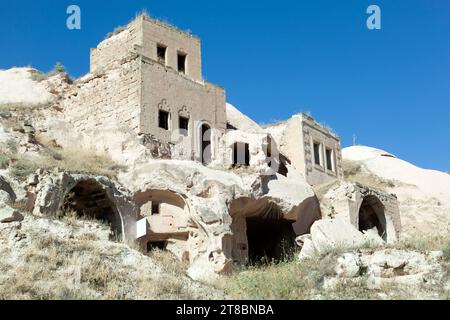 The view of houses and caves built into one residential structure in Cavusin village, Cappadocia region (Turkey). Stock Photo