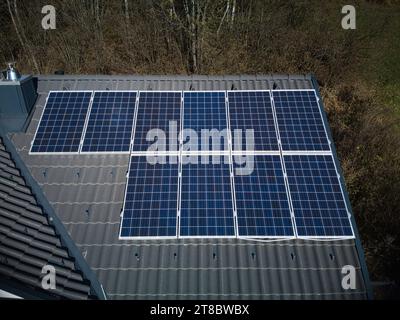 Experience the strength of solar technology on a resilient rooftop, captured from a drone's aerial perspective. Ten photovoltaic panels proudly stand Stock Photo