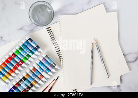 Watercolor paints set, paper, brushes, pencils close-up on a table, flat lay Stock Photo