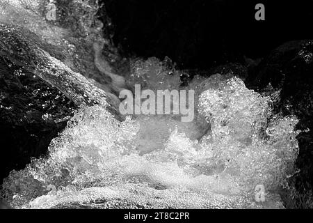 Bubbling Water Rushing Into a Creek; Black and White Image Stock Photo