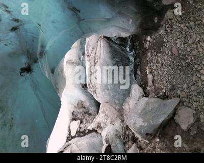 Climate change ice dripping in caves, arctic landscape in iceland. Water melting from massive ice rocks in icelandic vatnajokull iceberg crevasse, glacier hiking in winter wonderland. Stock Photo