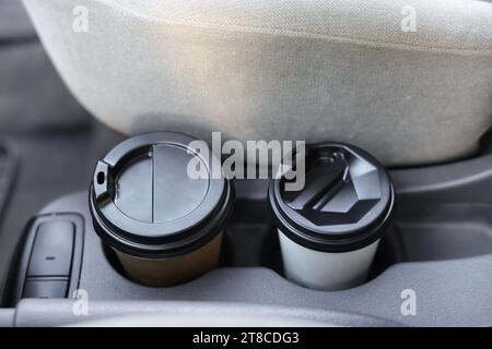 Coffee to go. Paper cups with tasty drink in holder inside of car, closeup Stock Photo